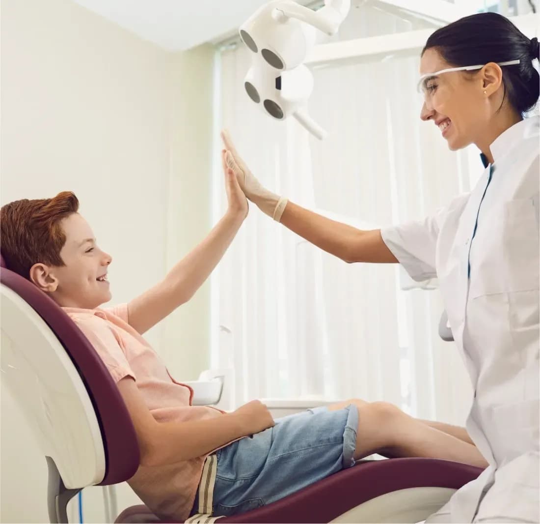 Niño chocando la mano con su doctora tras una consulta dental
